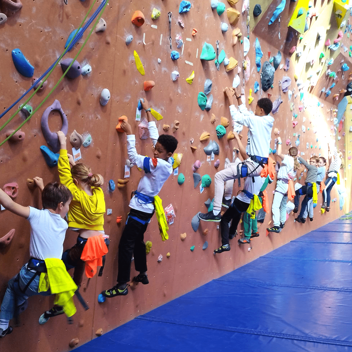 Des jeunes, accrochés à un mur d'escalade, sont en cours de partie d'un jeu d'escalade.